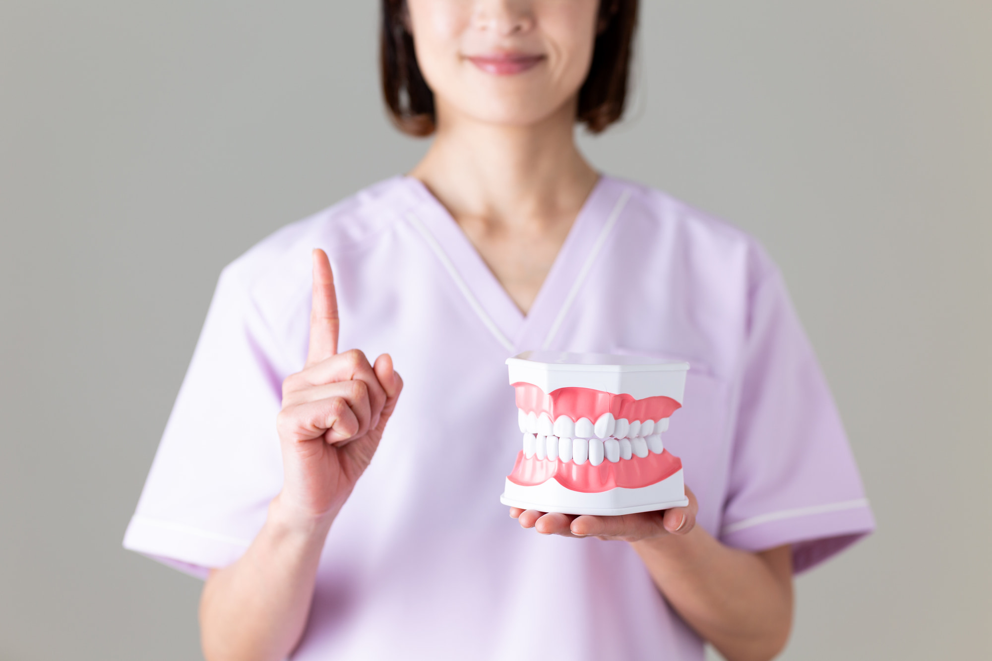 MFT（口腔筋機能療法）について歯の模型で説明する歯科医