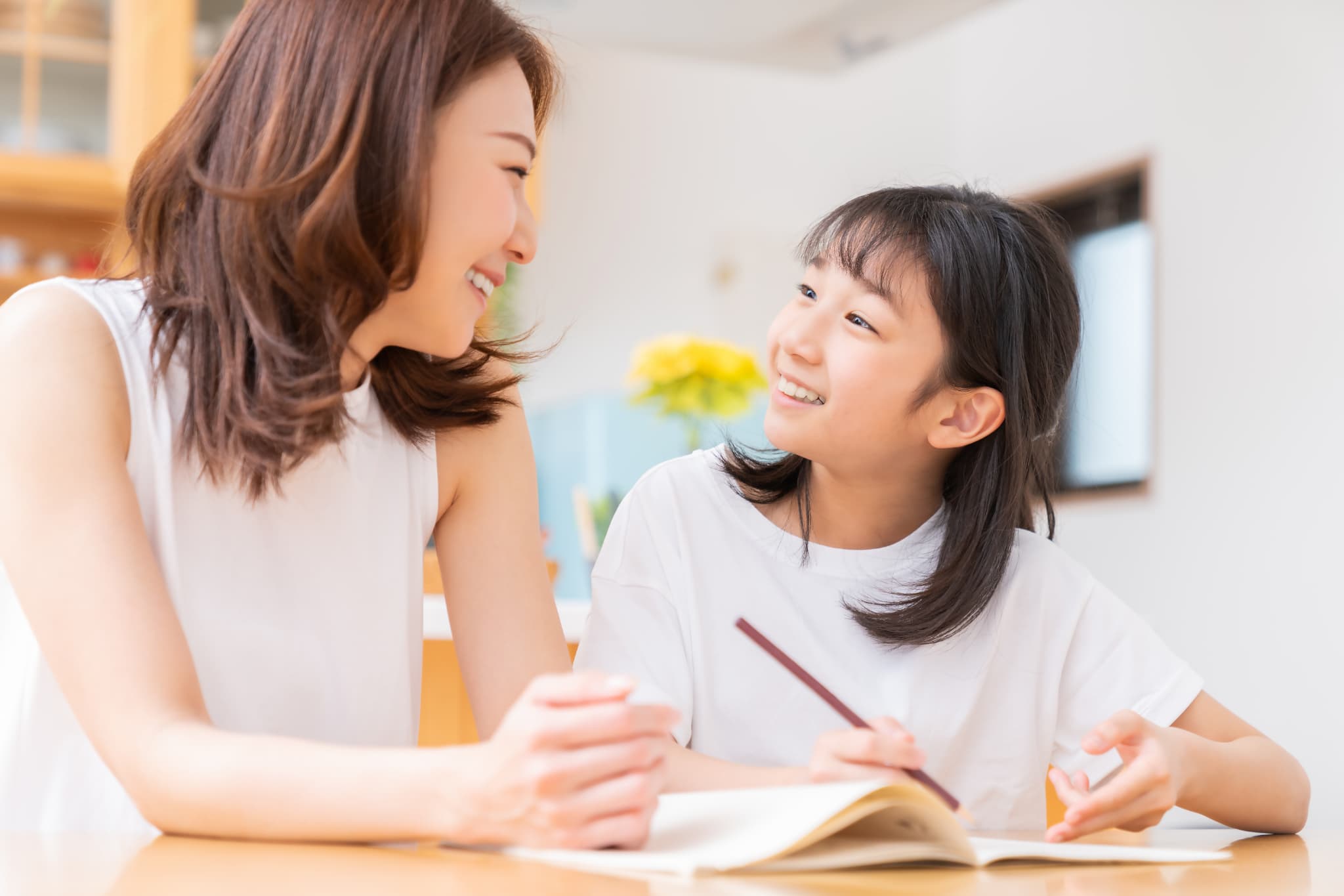 母親と勉強をしている矯正で整った歯並びの子ども